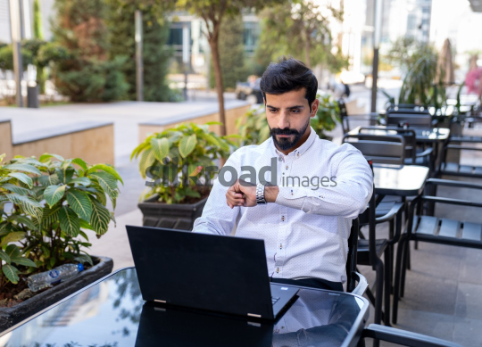 Professional Man Checking Watch for Meeting Time While Preparing for Zoom Call