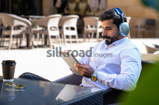 Professional Man with Headset Working on iPad at Desk with Coffee and Sunglasses