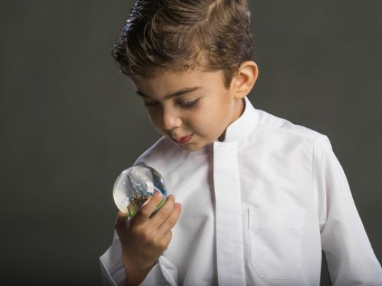 Little boy looking through snowball|