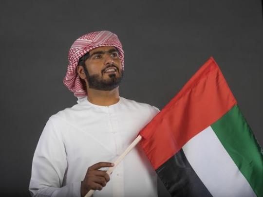Arab man carrying the UAE flag |