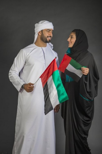 Man and Woman looking at each other carrying the UAE Flag