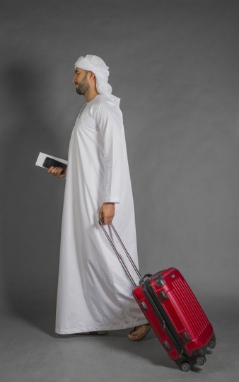 Businessman walking with carry on|-