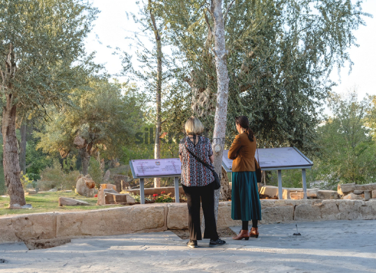 Tourists Exploring the Historical Signage at Mount Nebo, Jordan