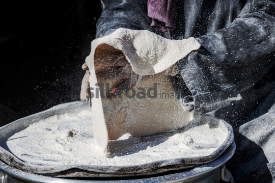 Woman Shaping Traditional Flatbread Dough with Flour in Rural Outdoors