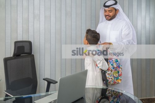 Middle Eastern Business man helping the young boy with his bag
