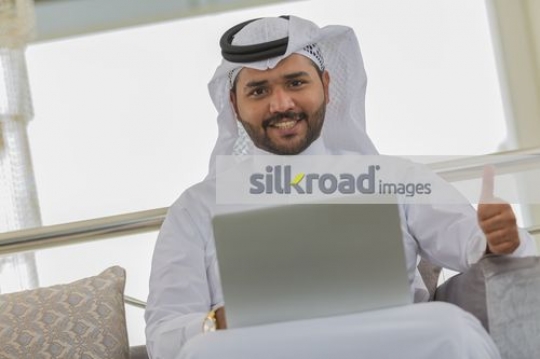 Businessman using the laptop thumbs up 