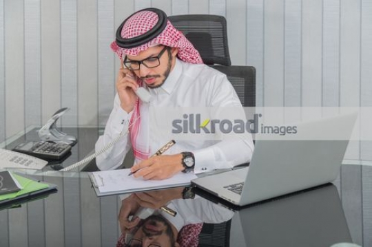 Businessman talking on the phone writing notes|